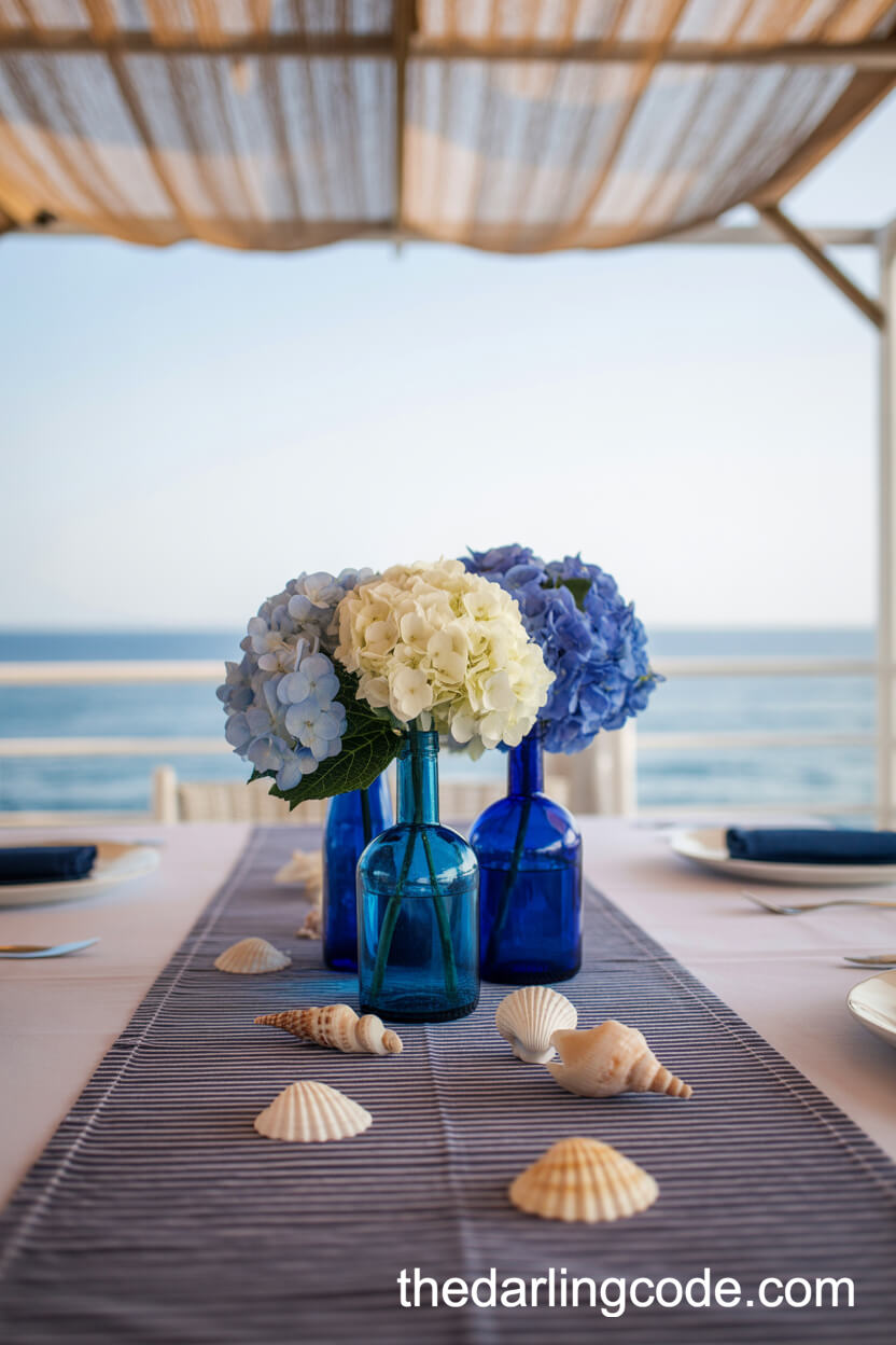 Blue Glass Bottles With Hydrangea And Seashells Centerpiece